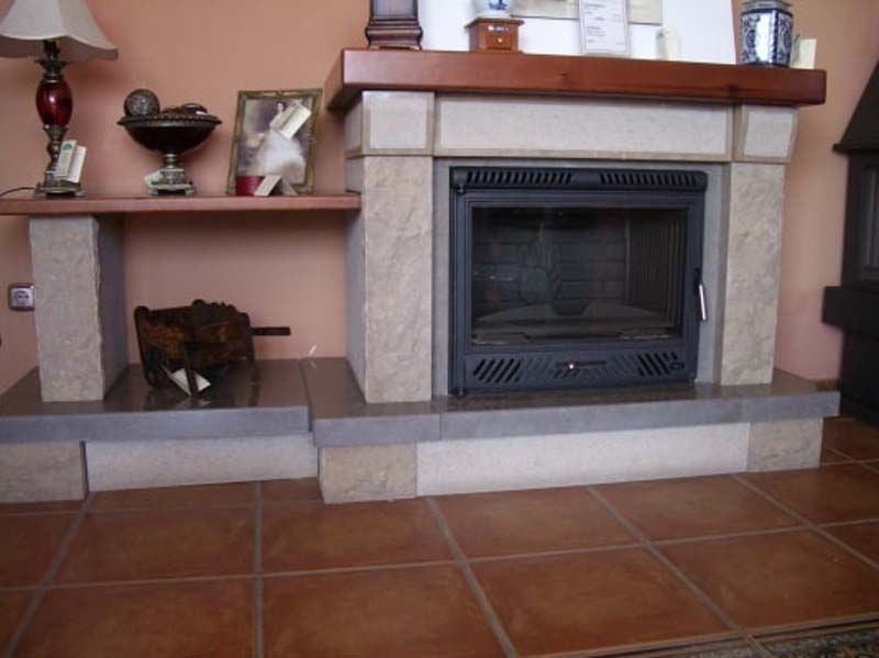 Una sala de estar con chimenea y lámpara.