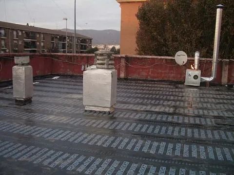 Un techo con una chimenea y una antena parabólica.