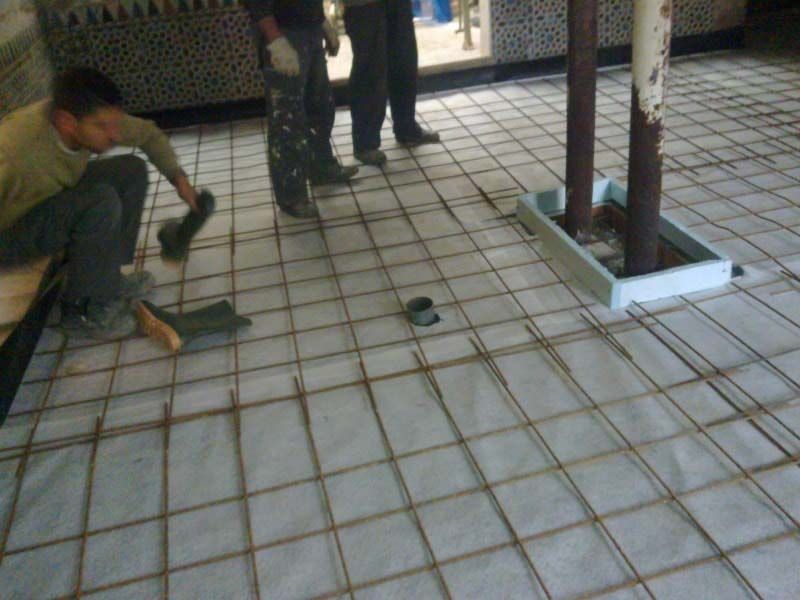 Un grupo de hombres está trabajando en un piso de baldosas.