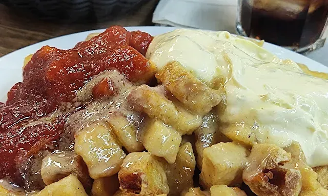 Un primer plano de un plato de comida con salsa y huevos sobre una mesa.