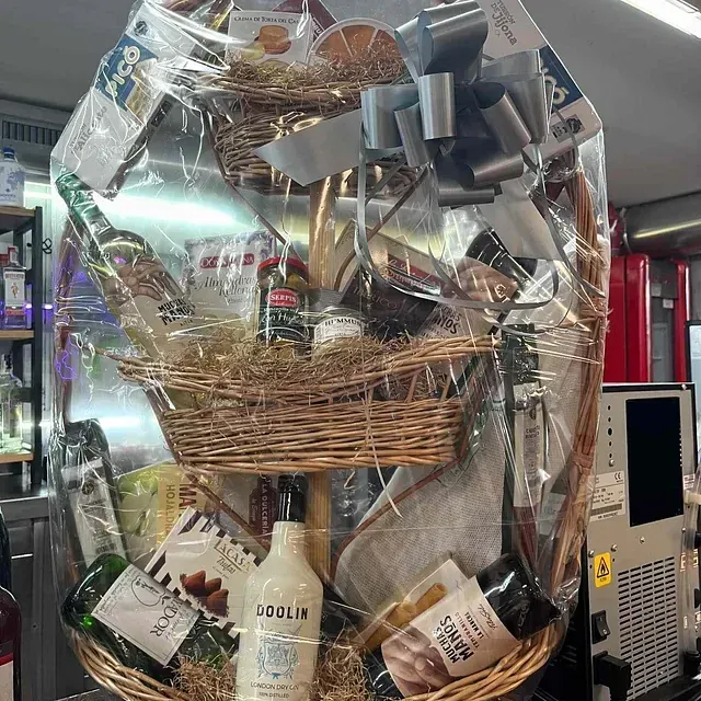 Una cesta de mimbre llena de botellas de vino y jabón