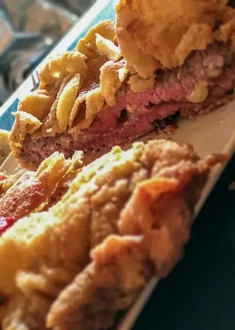 Un primer plano de un pastel y un sándwich en un plato.