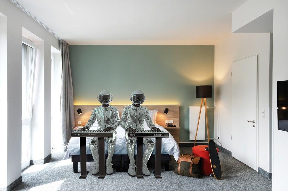 Zwei Roboter spielen Keyboard in einem Hotelzimmer