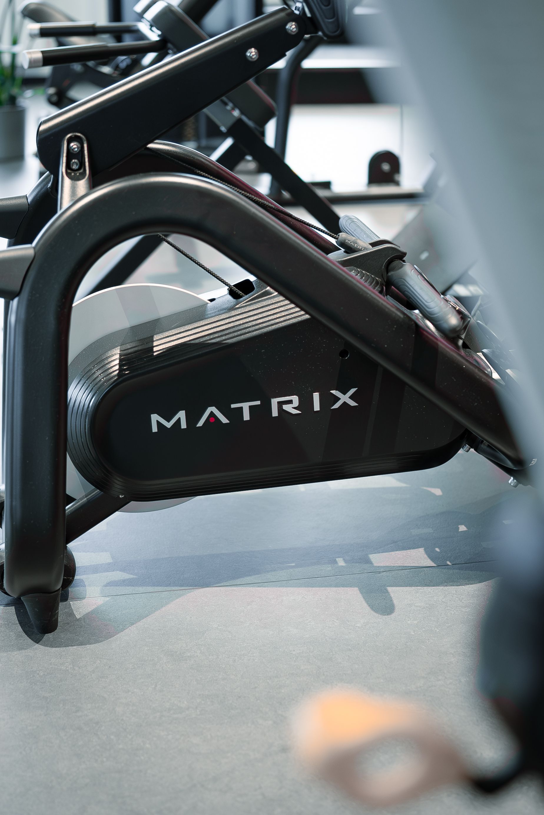 Nahaufnahme eines Matrix-Ellipsentrainers im Rooftop Gym. Schwarzer Rahmen, graues Gehäuse und eine schwarze Verkleidung.