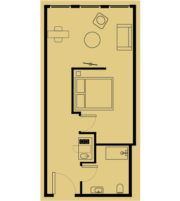 Floor plan of a small apartment. Includes a bed, seating area, bathroom with toilet and shower, and small kitchen area.