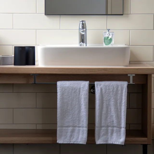 Ein Waschbecken im Badezimmer mit zwei Handtüchern darunter hängen in einem Hotelzimmer