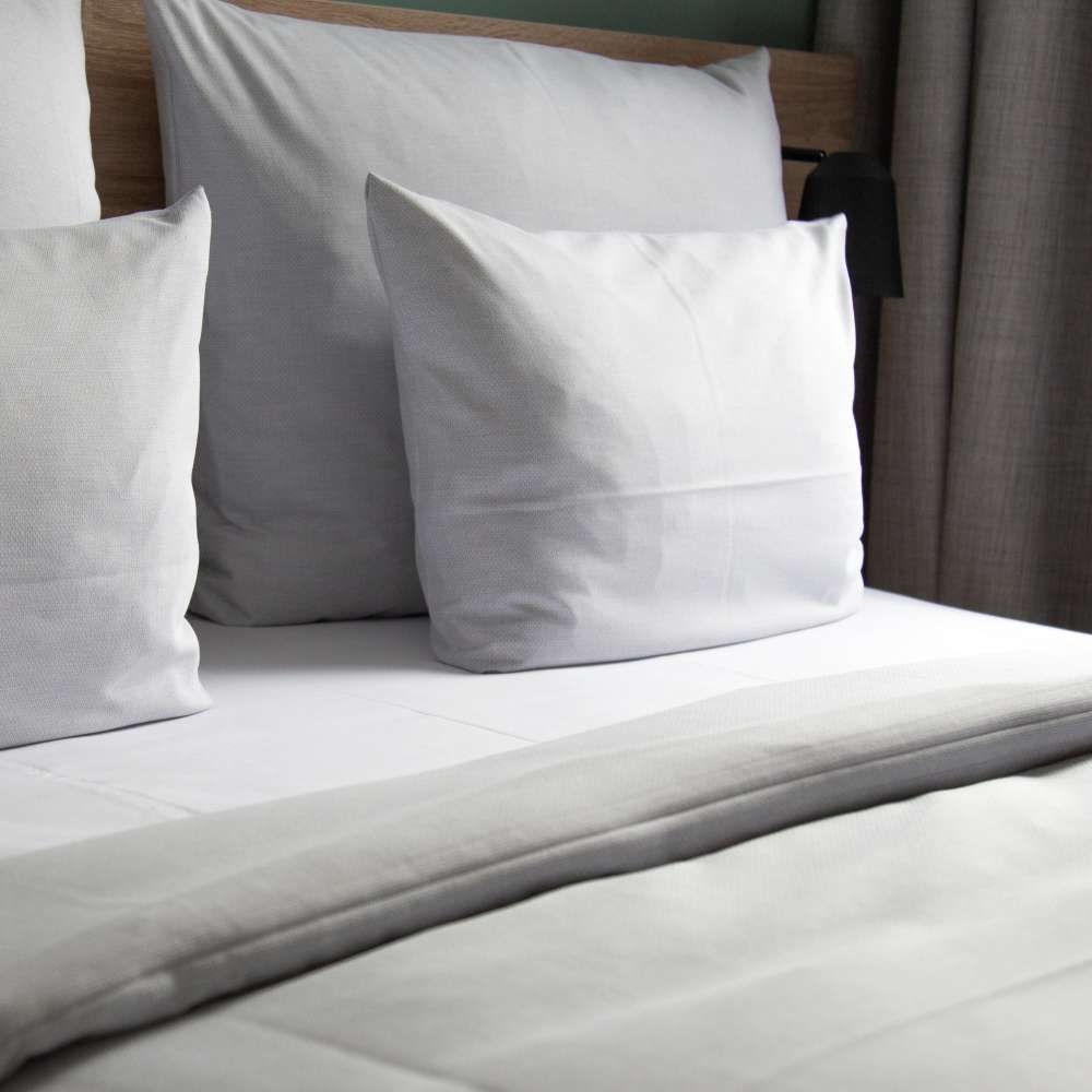 Ein Bett mit weißen Laken und Kissen darauf