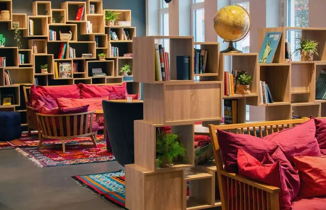 Ein Aufenthaltszimmer mit Couch, Stühlen, Regalen und einem Globus.