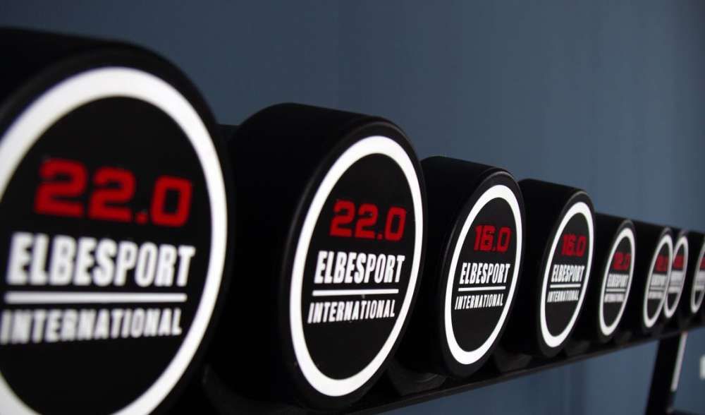 Eine Reihe von Elbesport International Hanteln auf einem Ständer