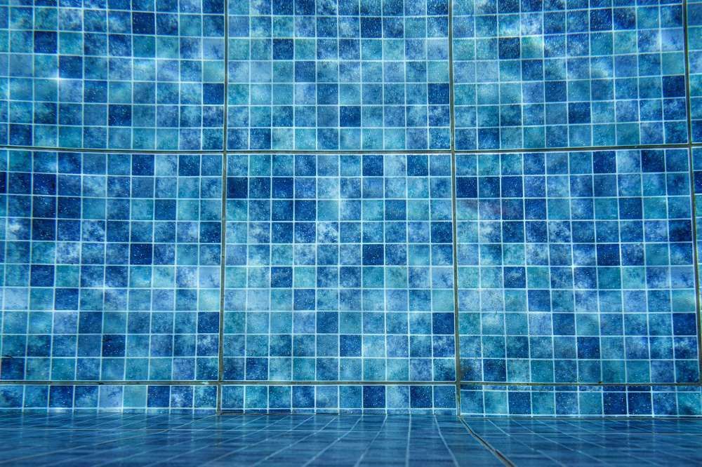 Ein Swimmingpool mit blauen Fliesen an Wand und Boden.