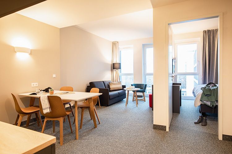 Ein Wohnzimmer mit Tisch, Stühlen und einer Couch.