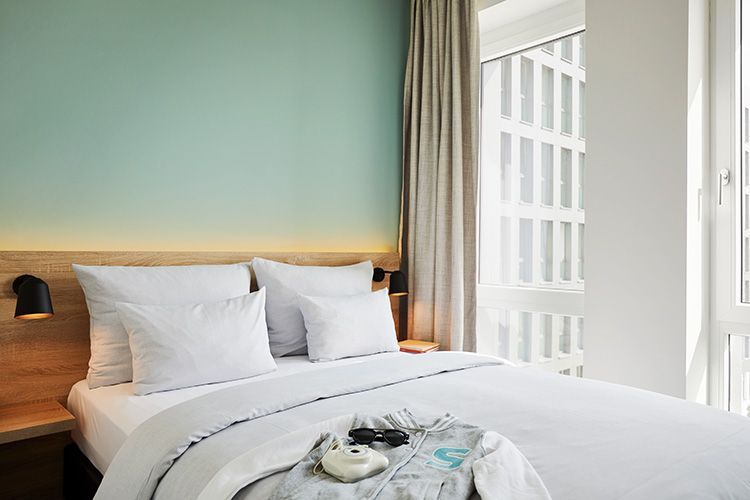 Ein Hotelzimmer mit einem großen Bett und einem Fenster.