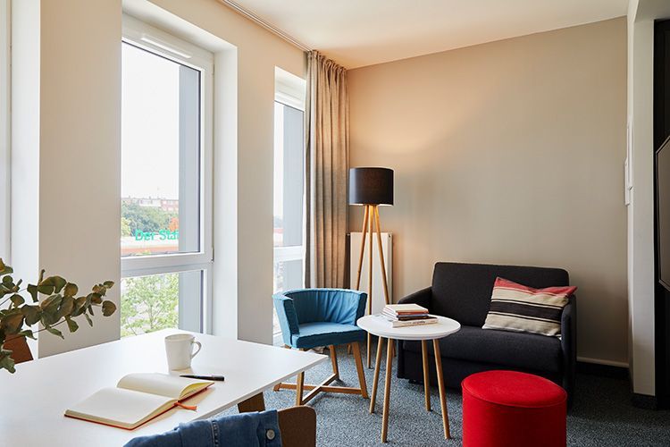 Ein Wohnzimmer mit Sofa, Stühlen, Tischen und einem Fenster.