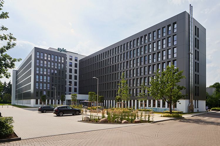 Ein großes Gebäude mit davor geparkten Autos