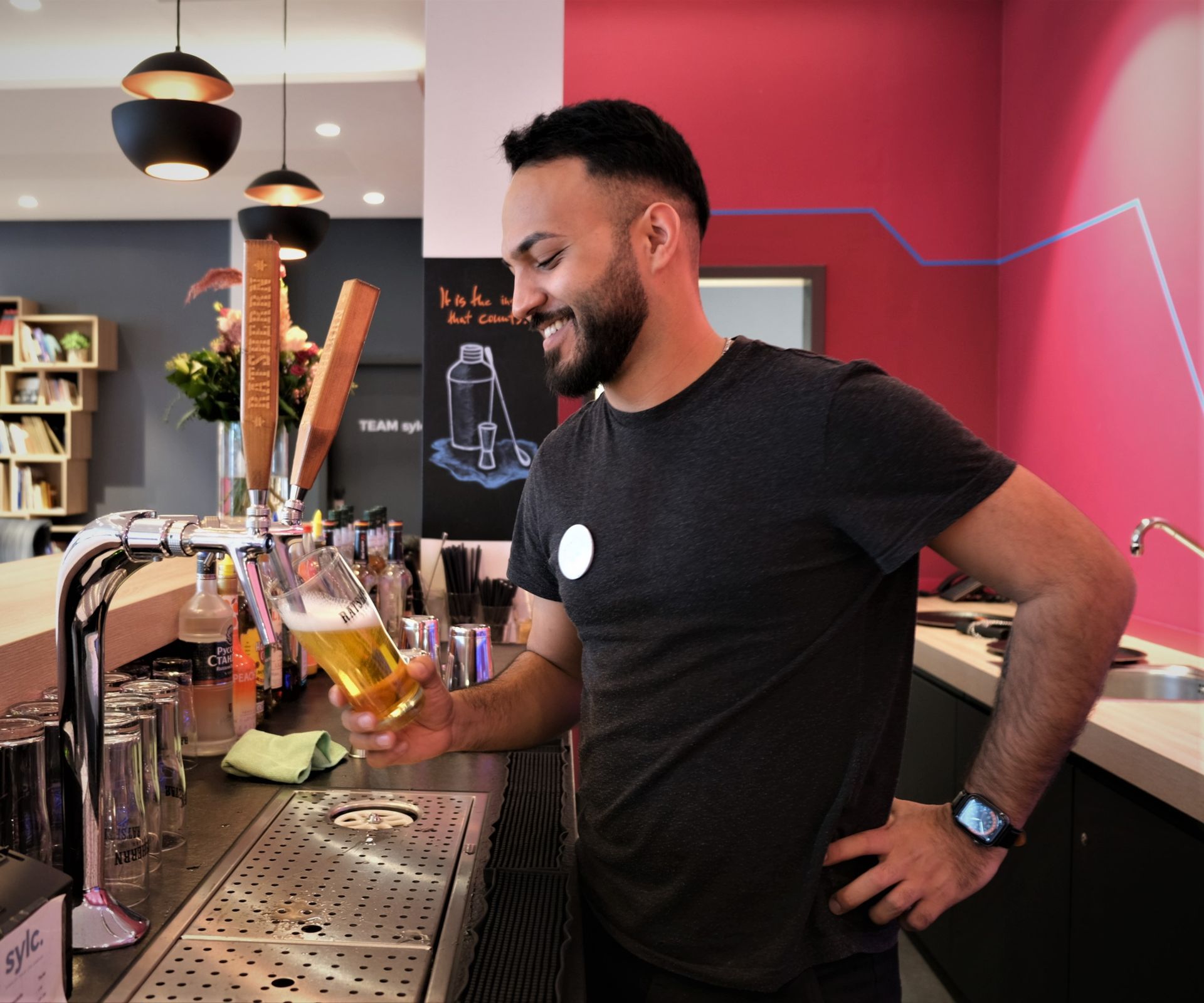 Ein Mann gießt in einer Bar Bier in ein Glas