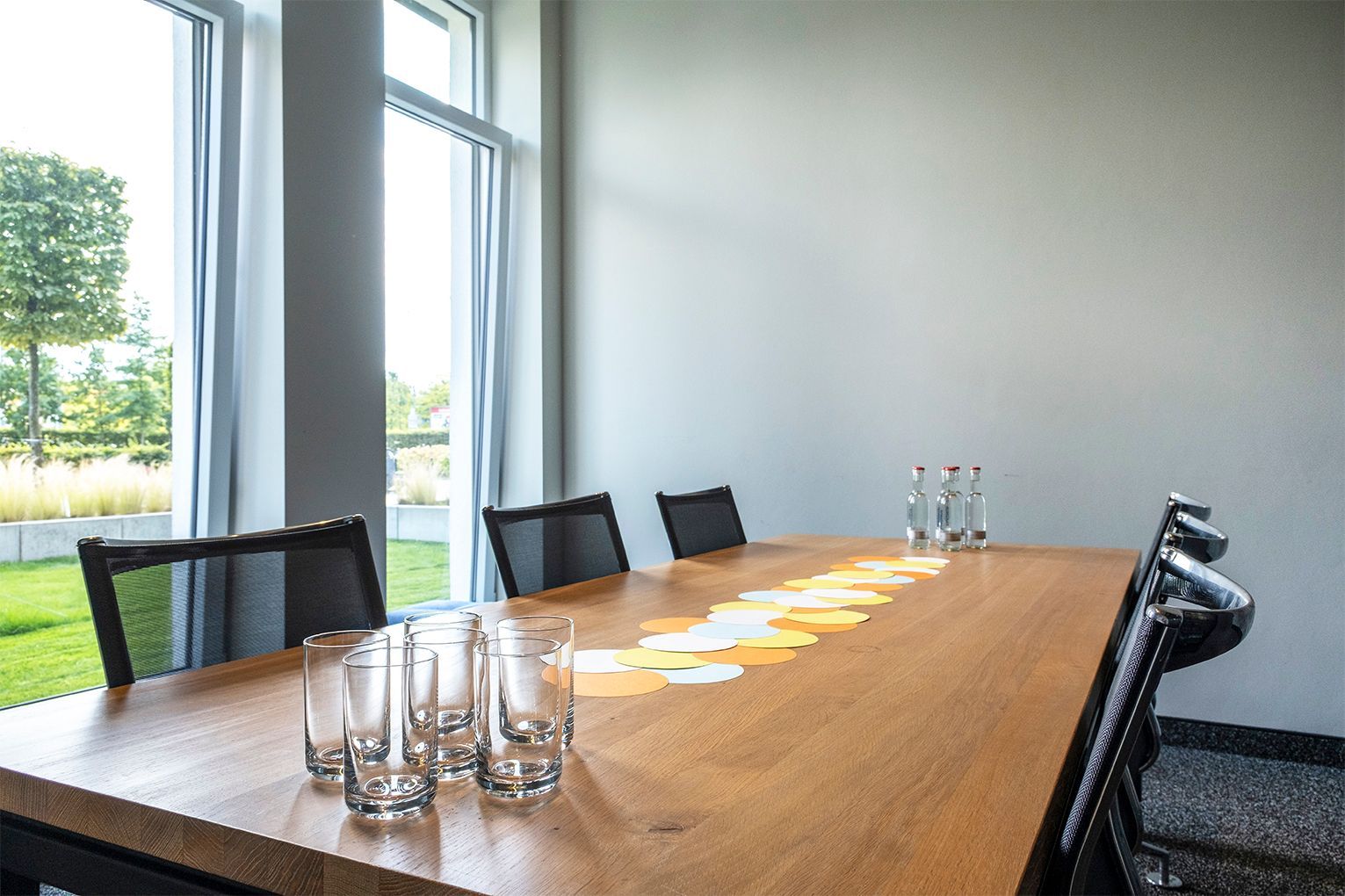Meetingraum Study II mit einem langen Holztisch, schwarzen Stühlen und hohen Fenstern mit Blick ins Grüne