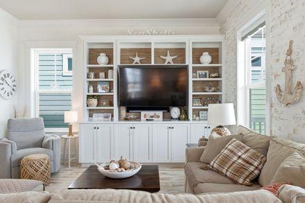 Just Beachy living room with white built in shelving, coastal decor and a wall mounted television