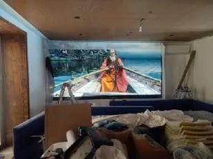 Una habitación con un sofá y una pantalla grande en la pared.