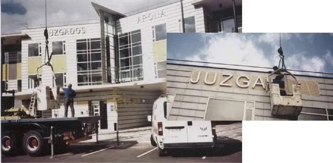 Una camioneta blanca está estacionada frente a un edificio que dice juzga