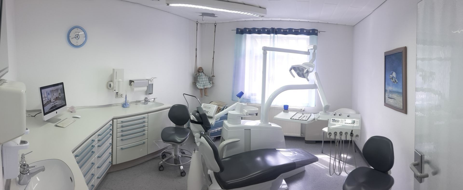 Behandlungsraum mit einem Zahnarztstuhl und einem Computer