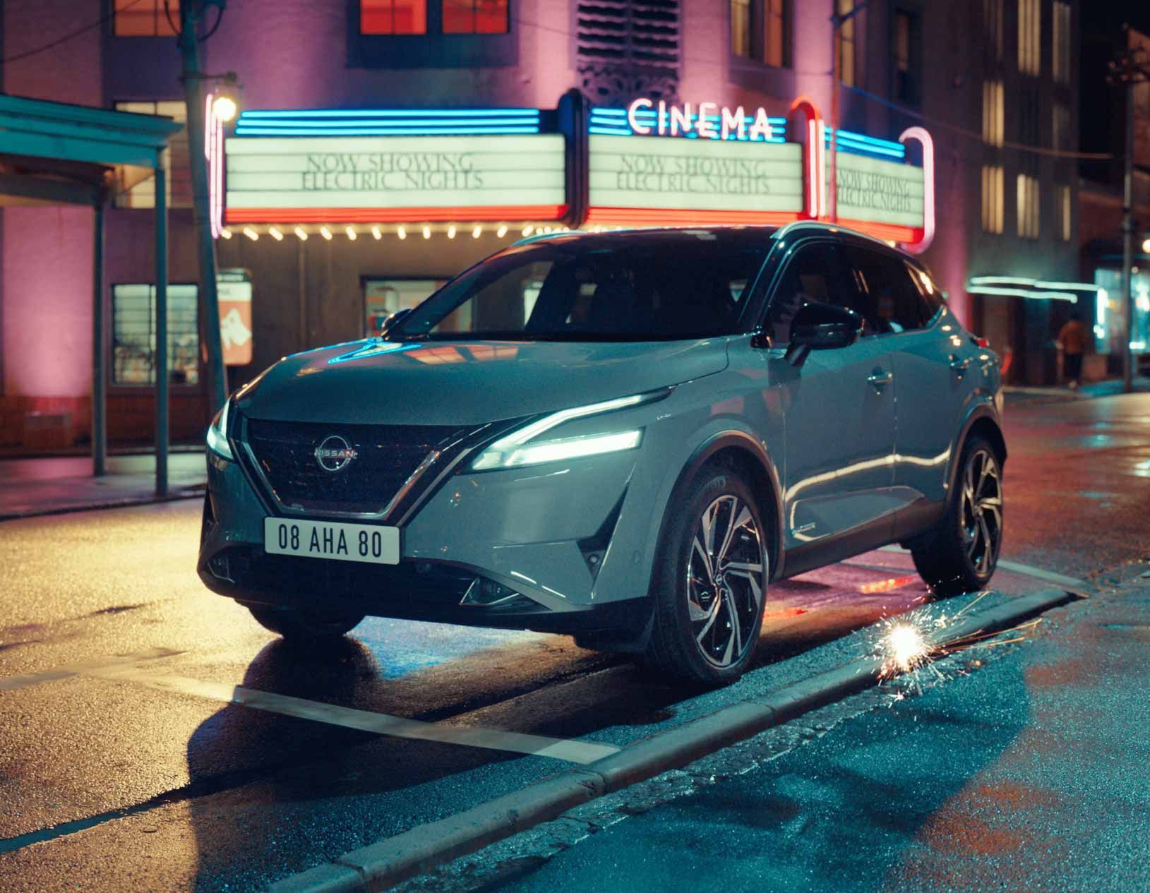 Un véhicule hybride de la marque Nissan dans un environnement citadin de nuit