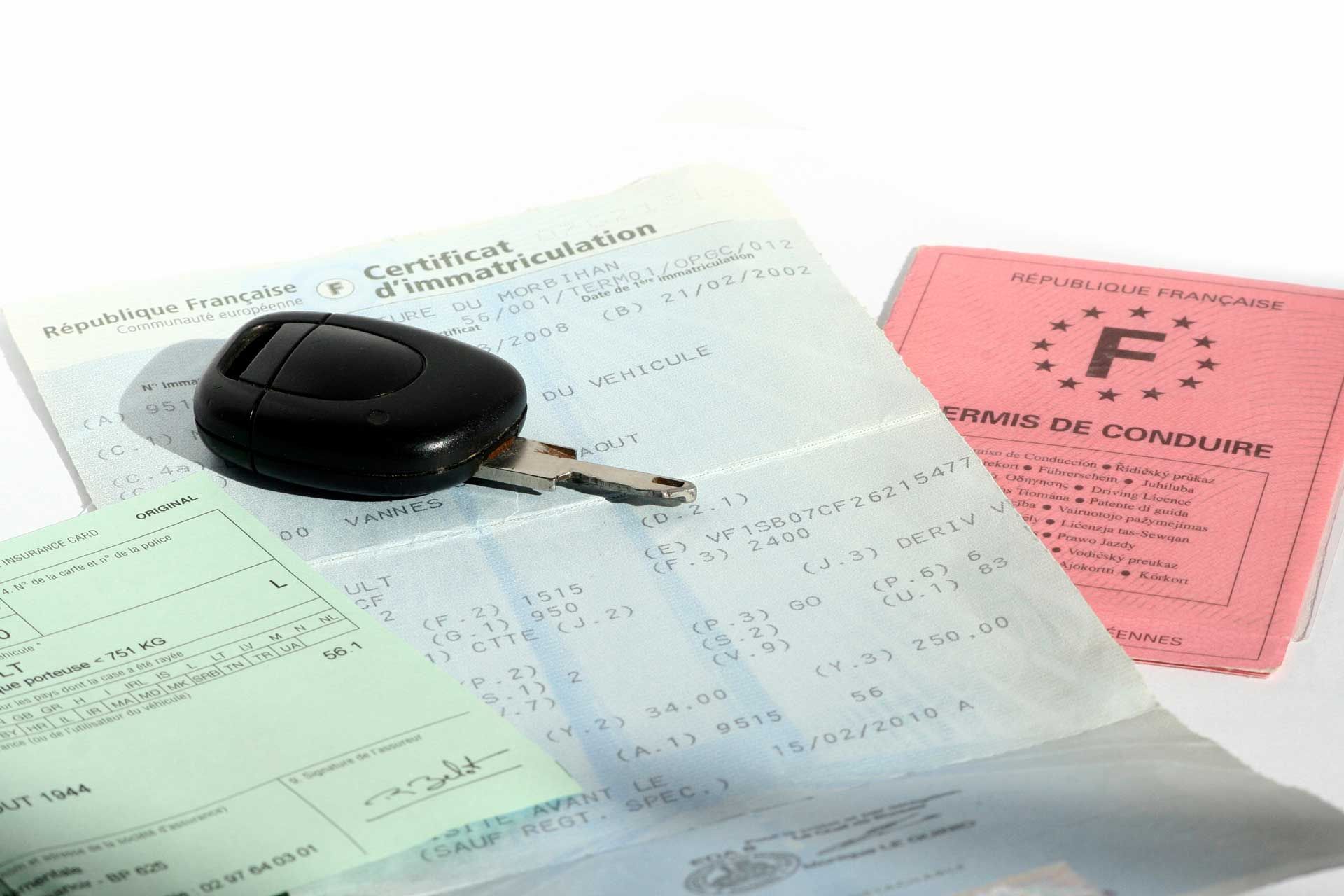 Clef de voiture sur une carte grise avec un permis et un contrat d'assurance