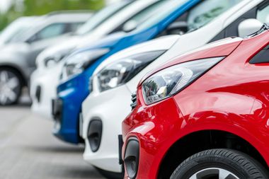 Rangée de voitures colorées sur un parking extérieur