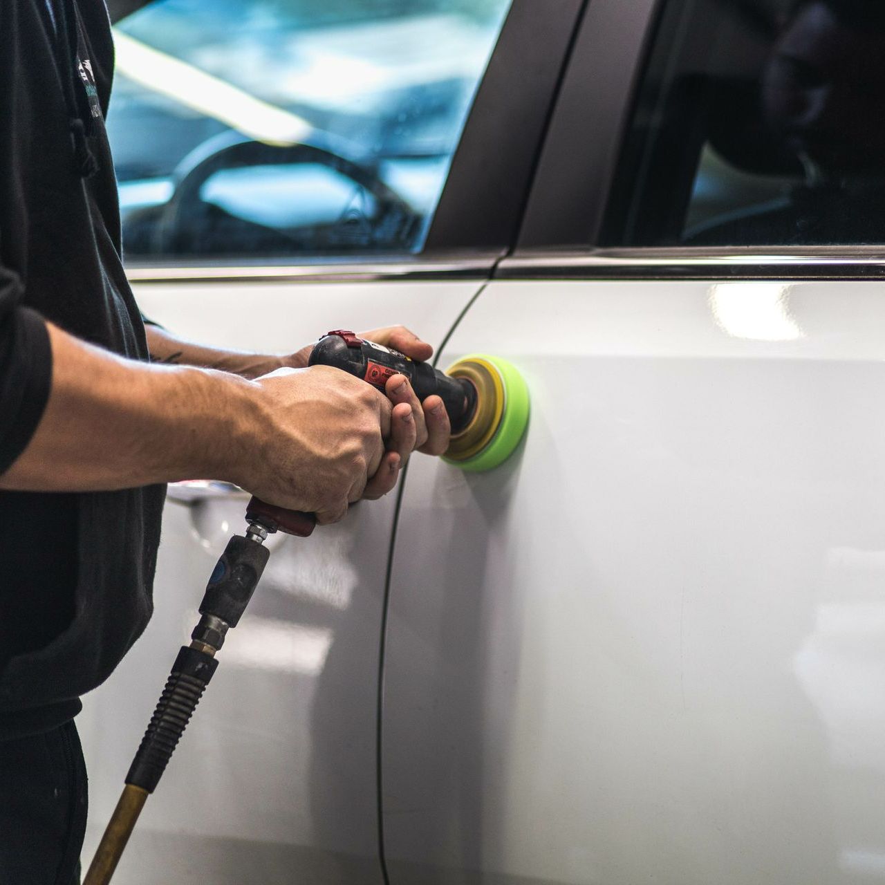 Carrossier intervenant sur la carrosserie d'une voiture