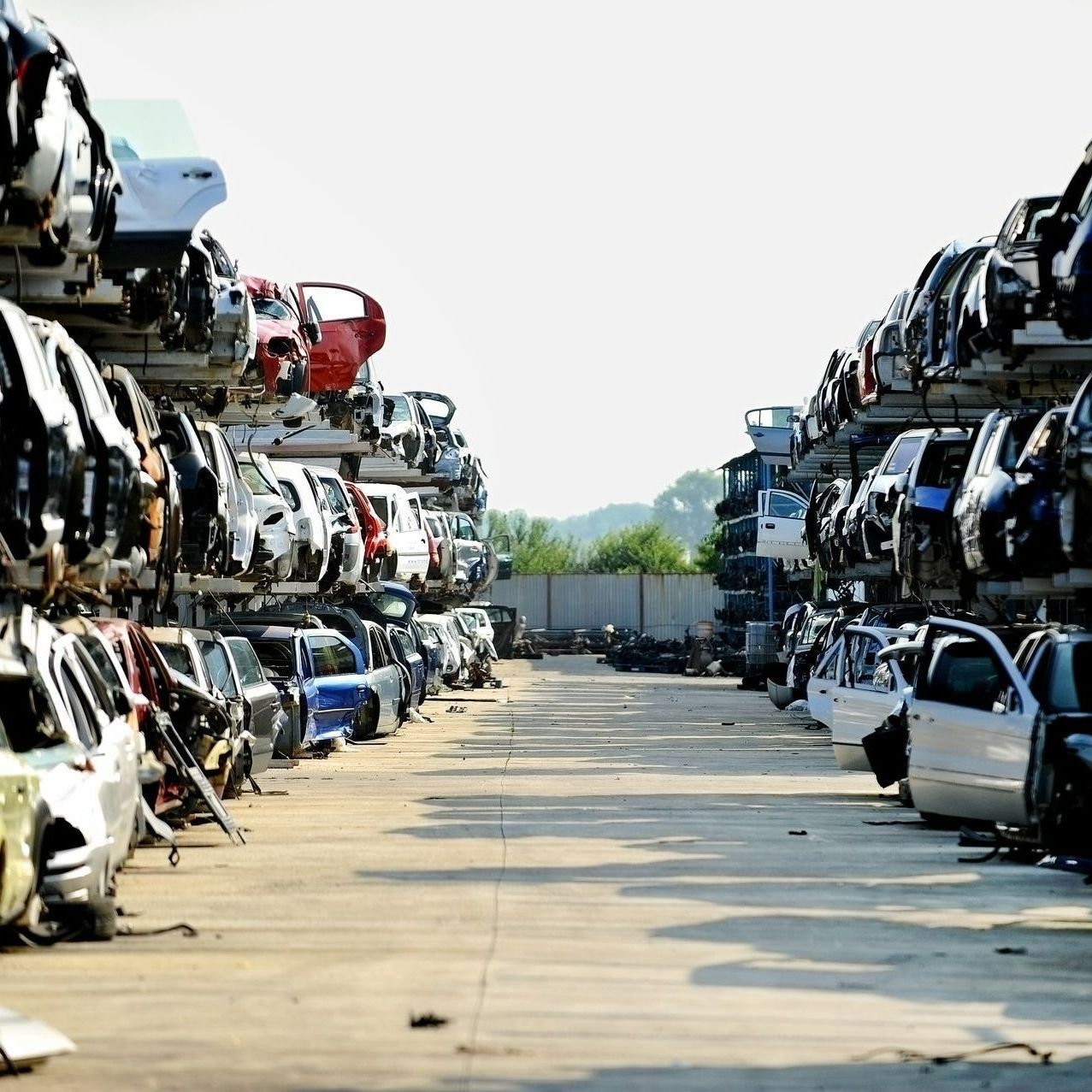 Allée de voitures empilées dans une casse automobile
