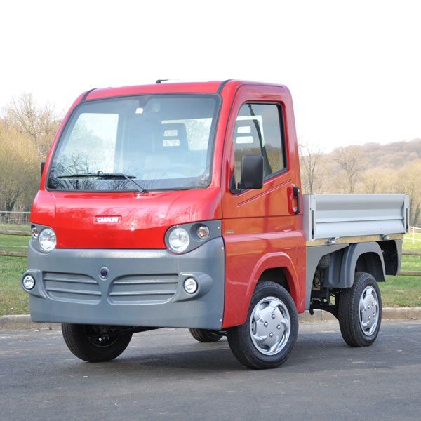 Camionnette utilitaire rouge devant un champ