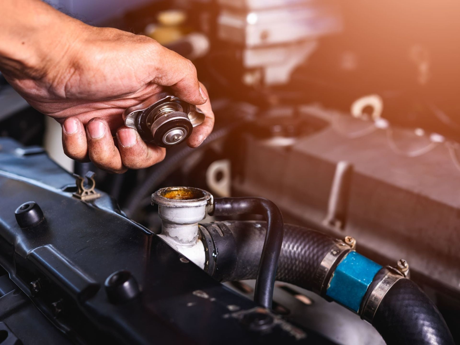 Una persona está trabajando en el radiador de un coche.