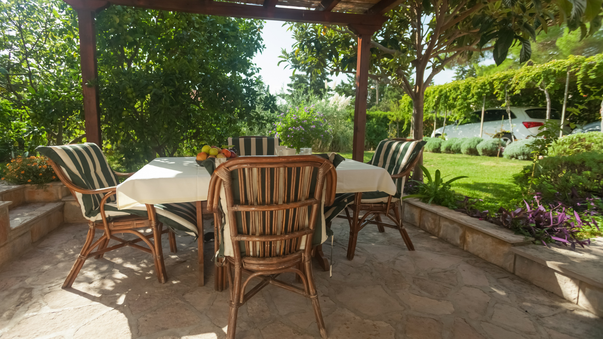 Espace repas extérieur avec table, chaises et verdure.
