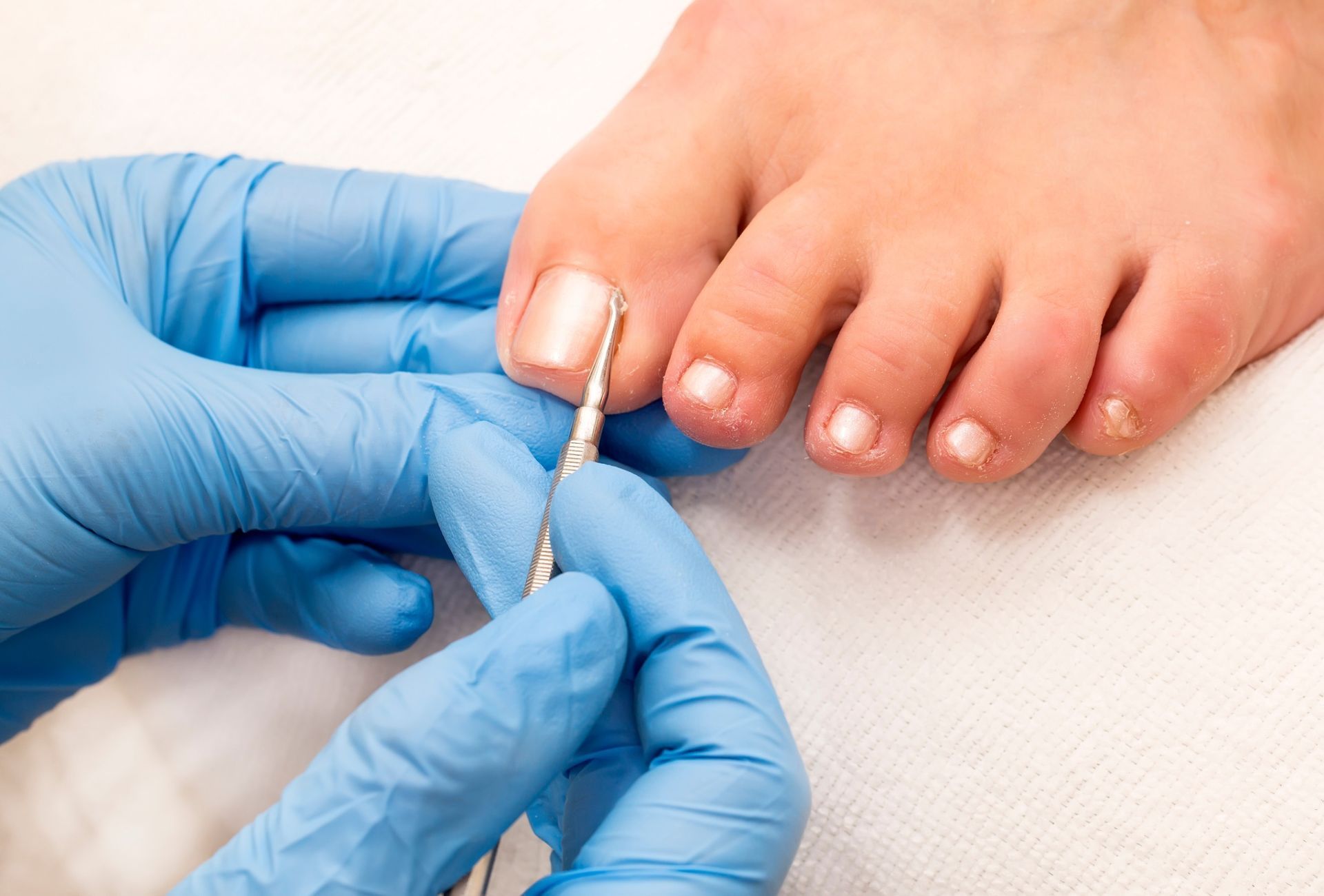 Una persona se está pintando las uñas de los pies con un artista de uñas.
