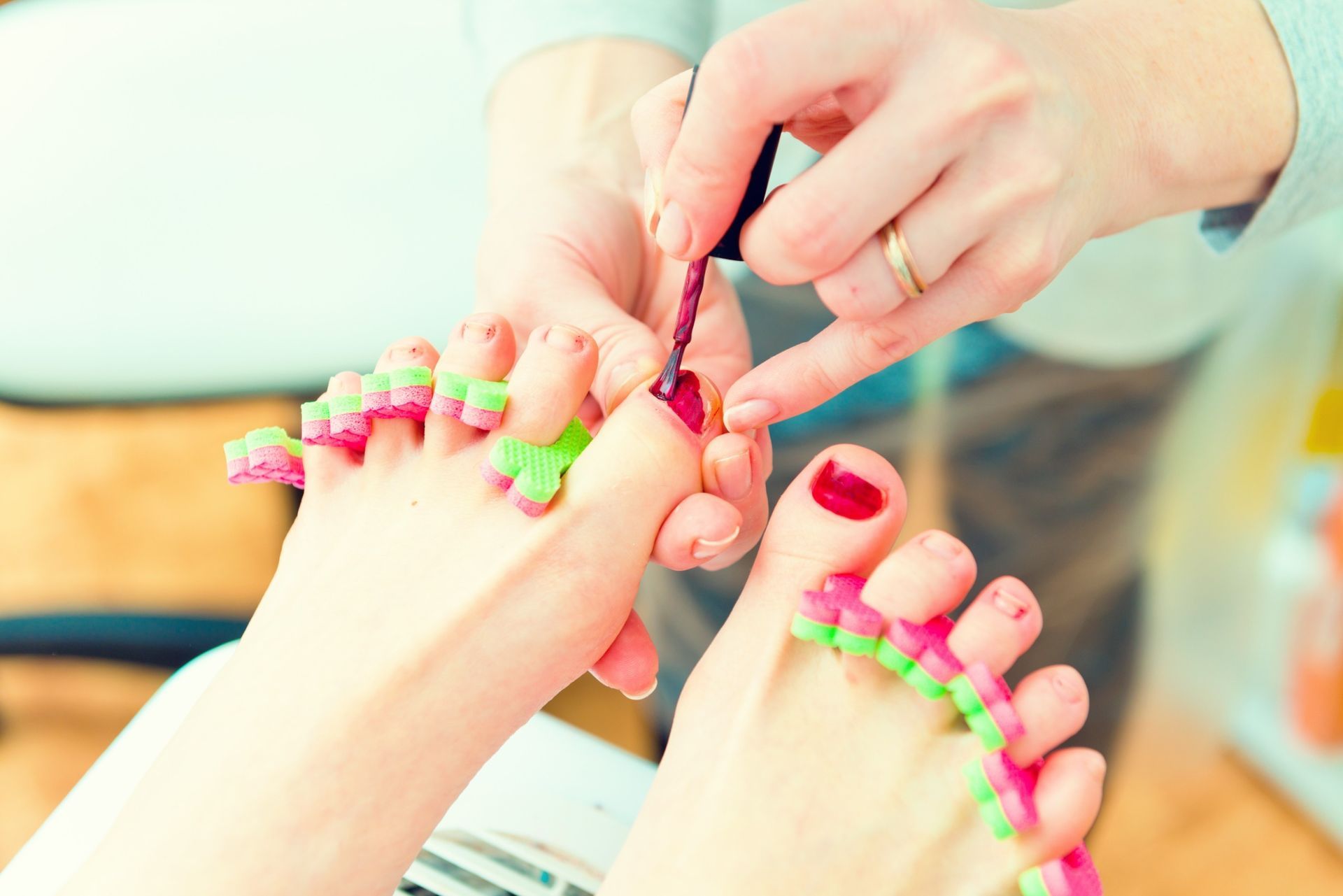 Una mujer se está pintando los pies con un artista de uñas.