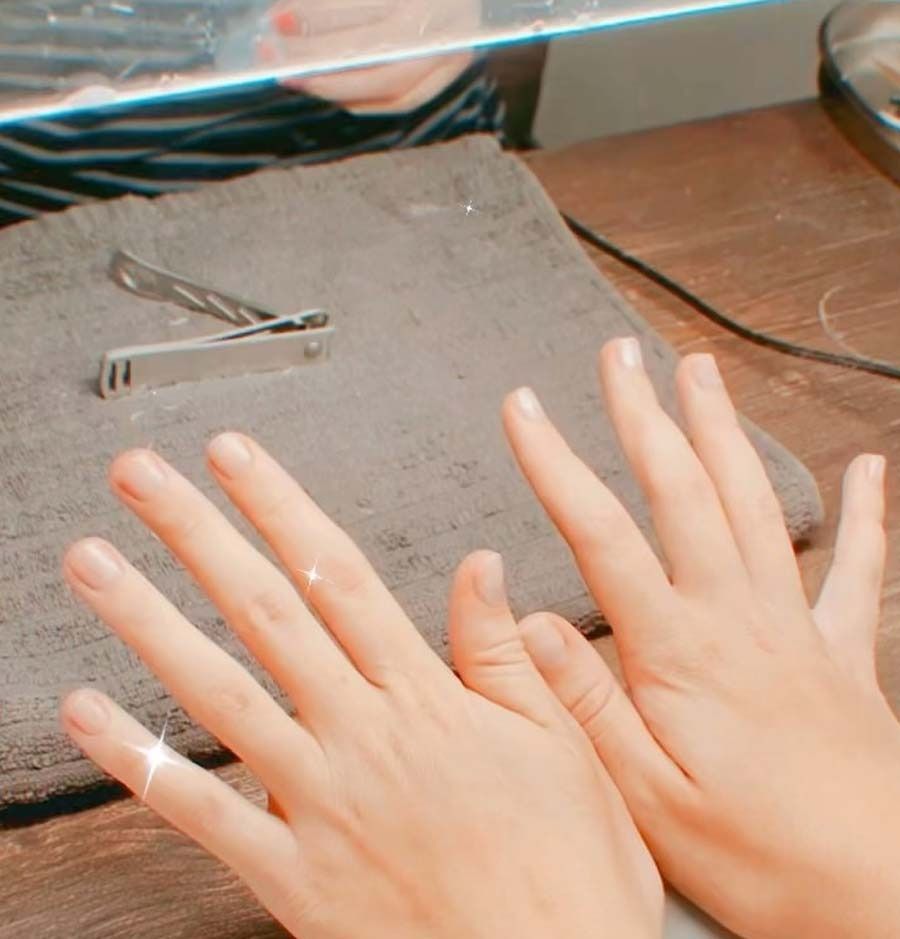 Una persona se está cortando las uñas con un cortaúñas.