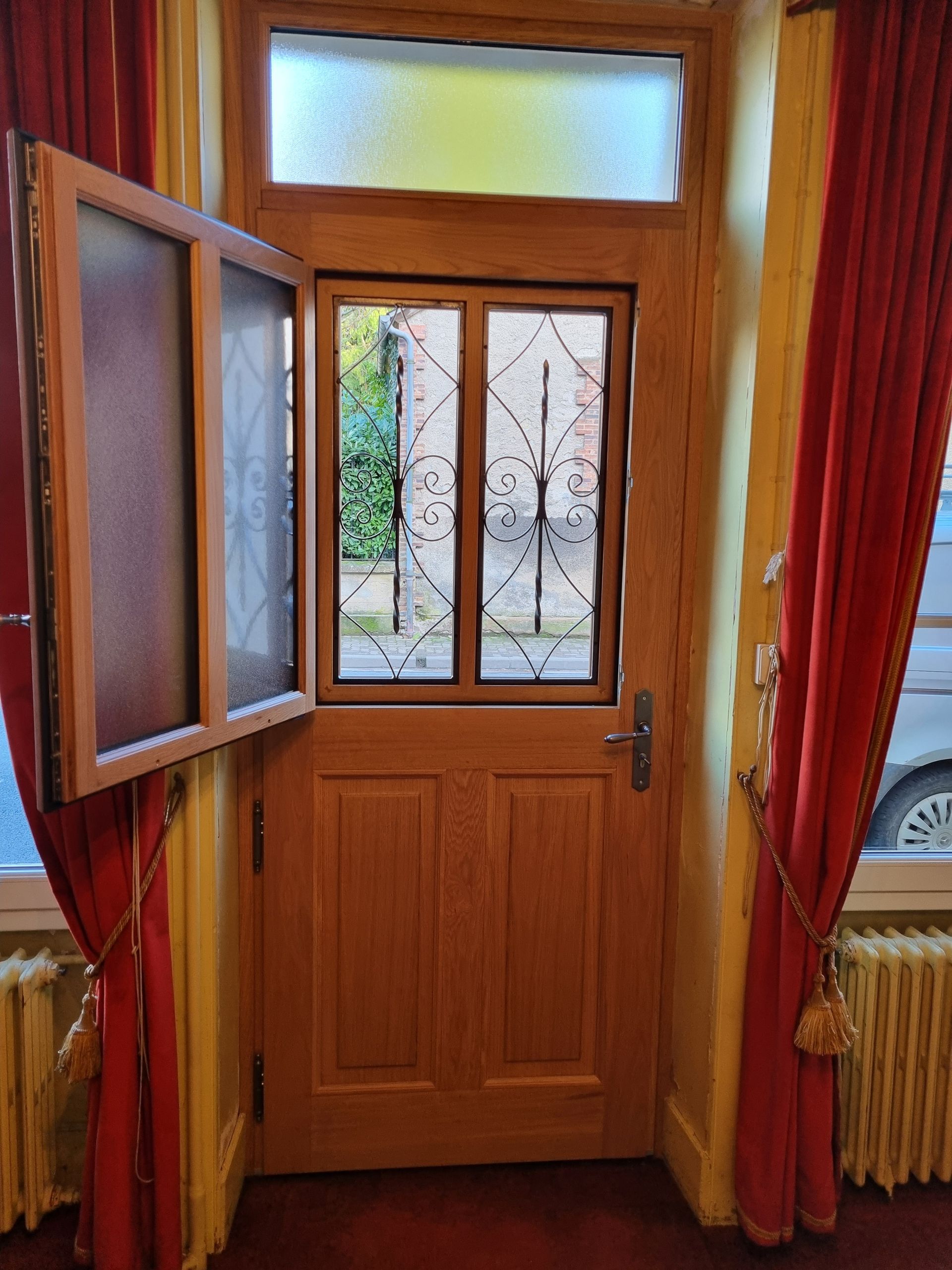 Porte d’entrée en bois avec une vitre.