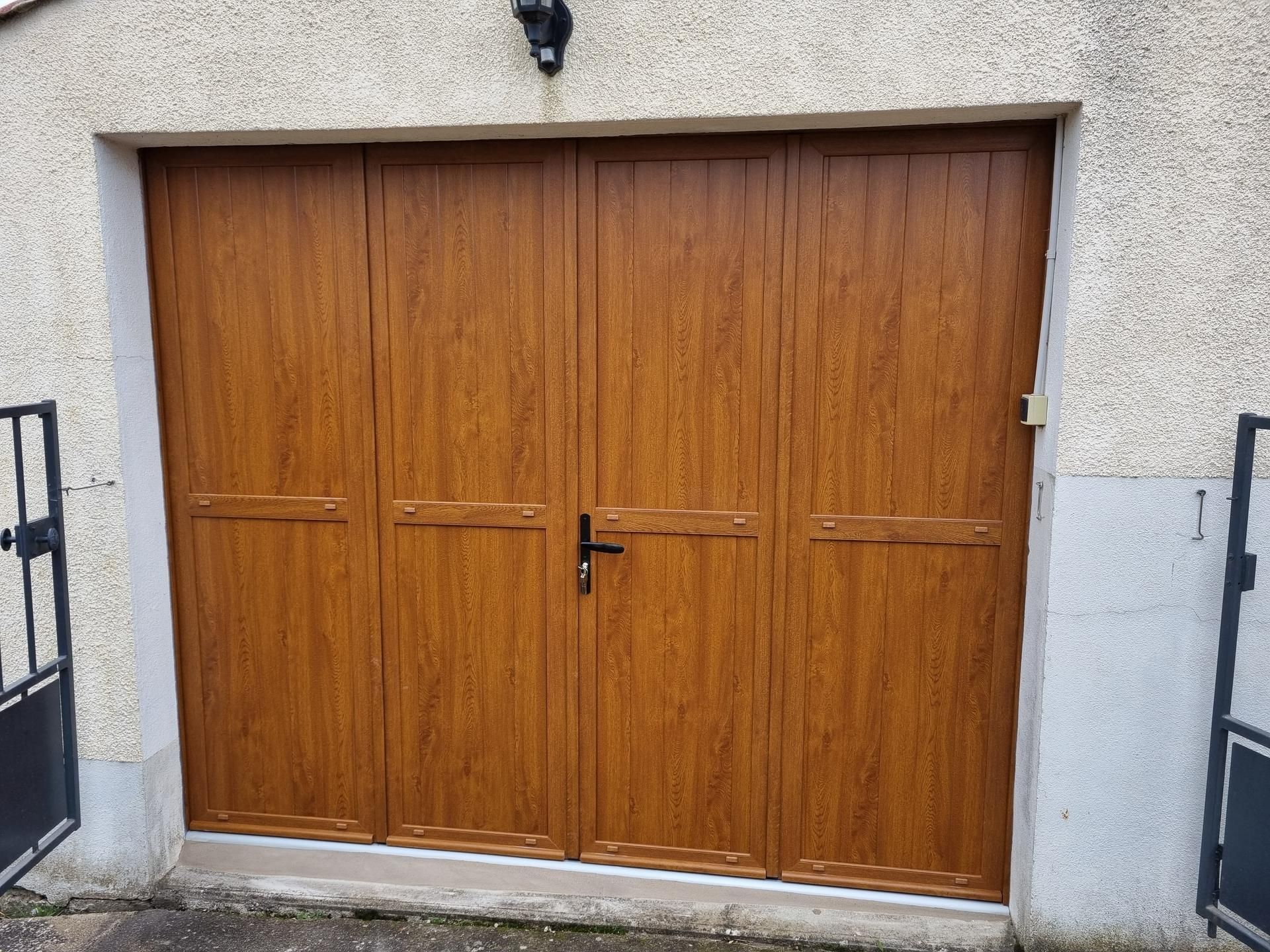 Porte de garage en bois avec une poignée centrale.
