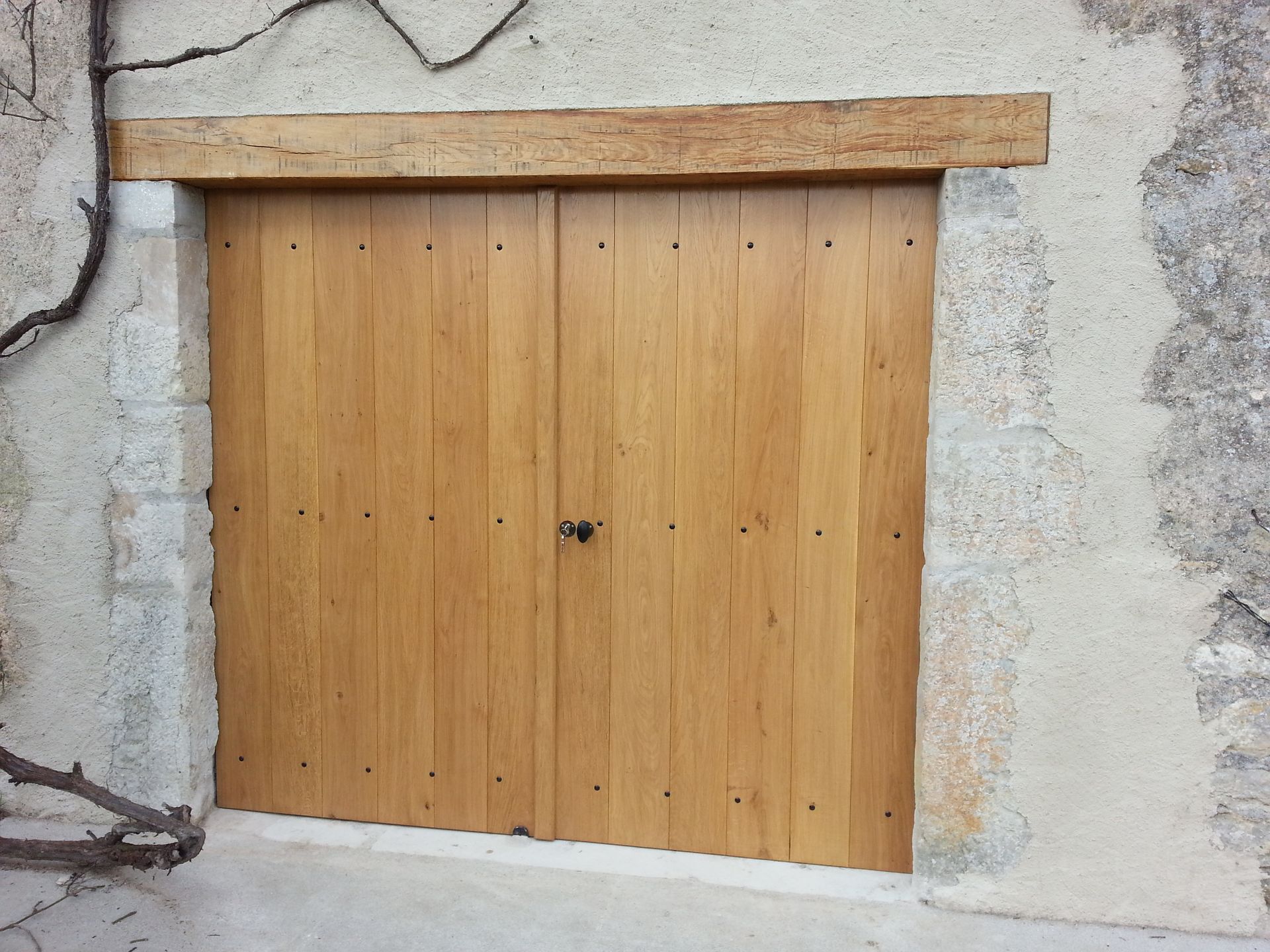 Porte en bois encastrée dans un mur de pierre brute.
