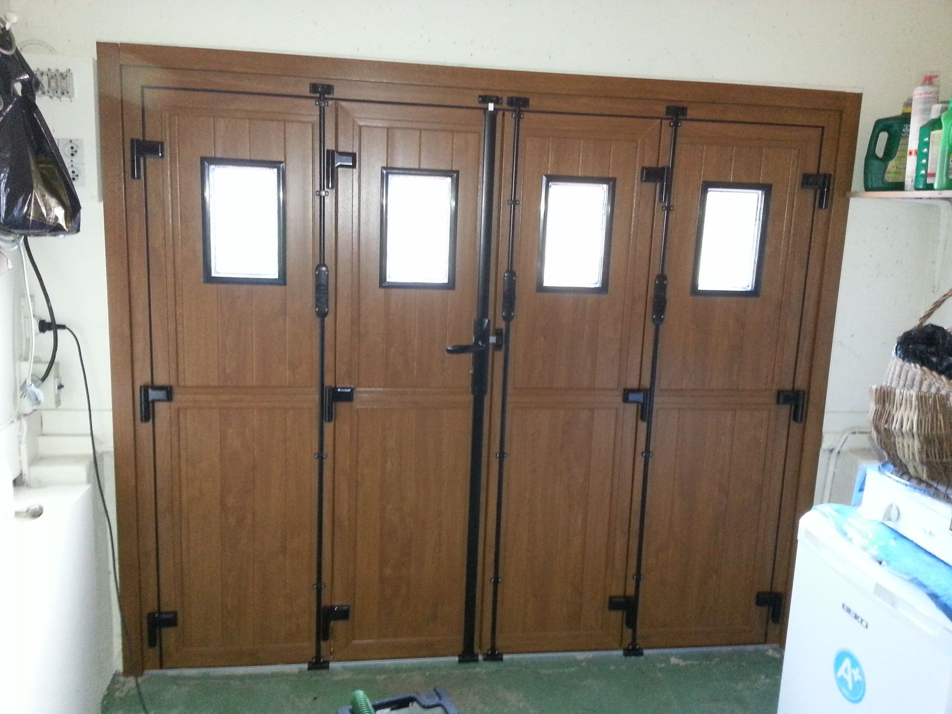 Portes de garage en bois avec de petites fenêtres dans un couloir intérieur.