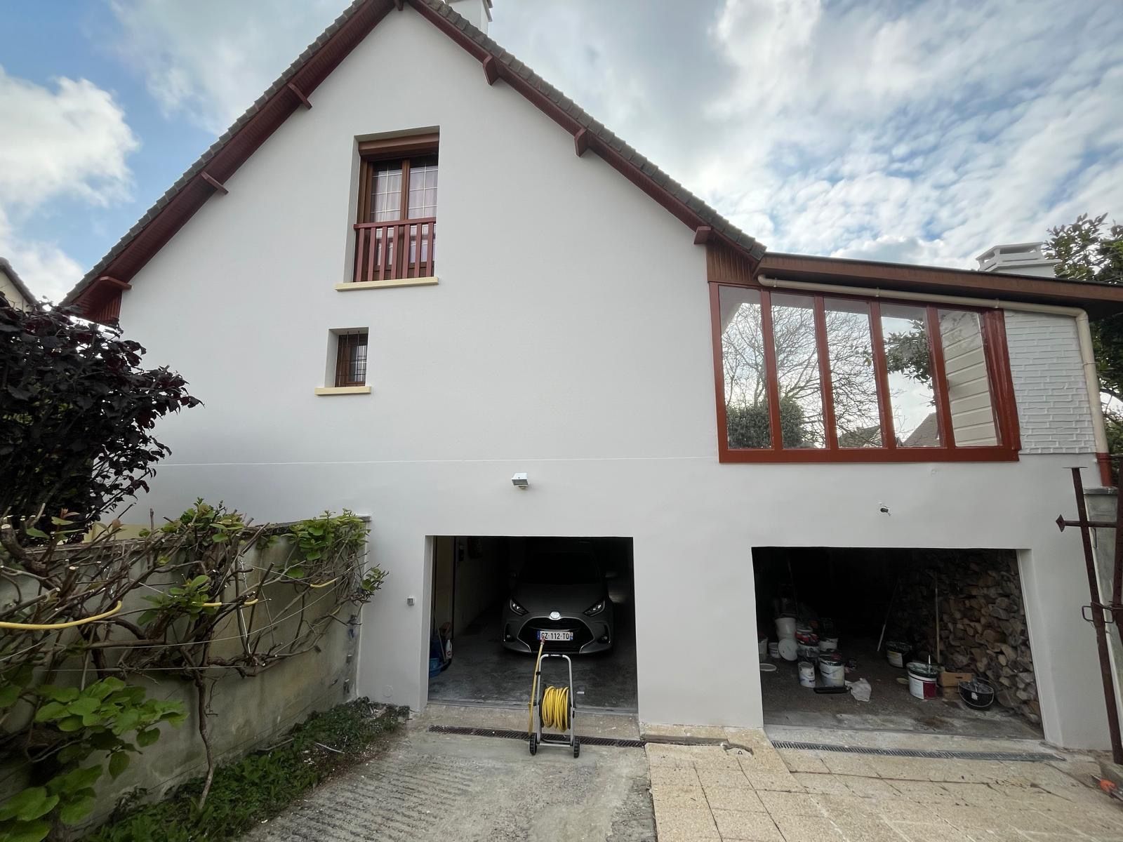Façade d'une maison avec menuiseries rouges
