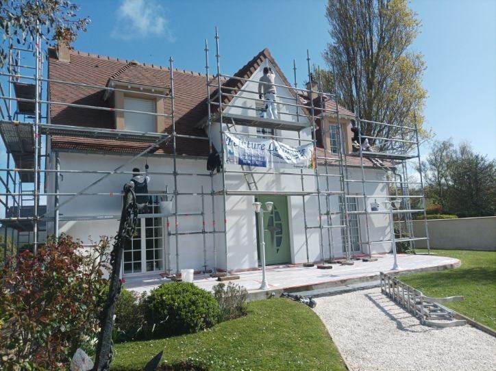 Ravalement de façade d'une maison à la porte verte