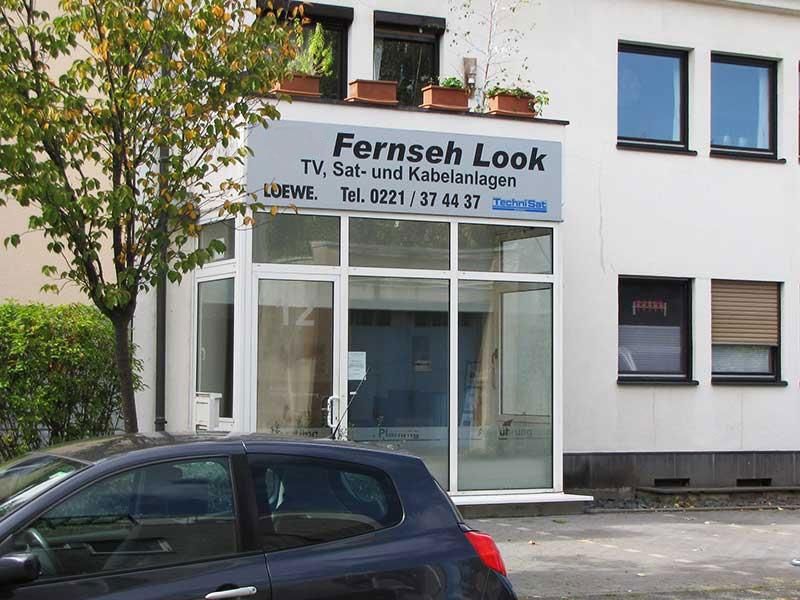 Ein Auto steht vor einem Gebäude mit der Aufschrift „Fernsehen Look“