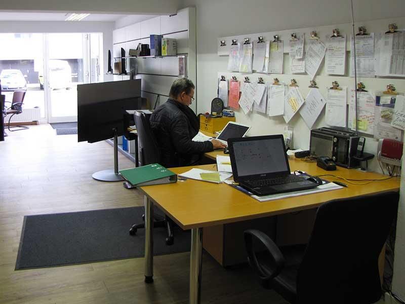 Ein Mann sitzt an einem Schreibtisch mit einem Laptop darauf