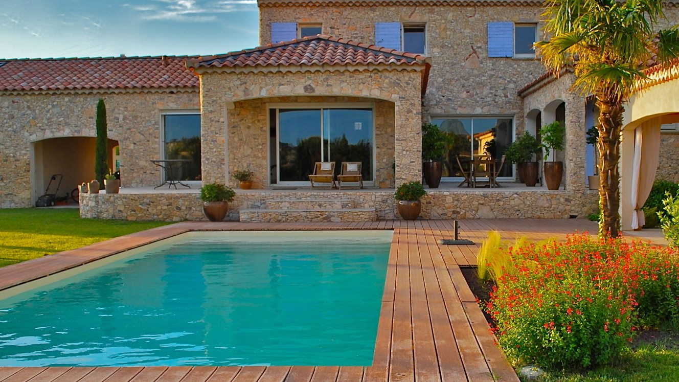 Une maison en pierre avec piscine et terrasse