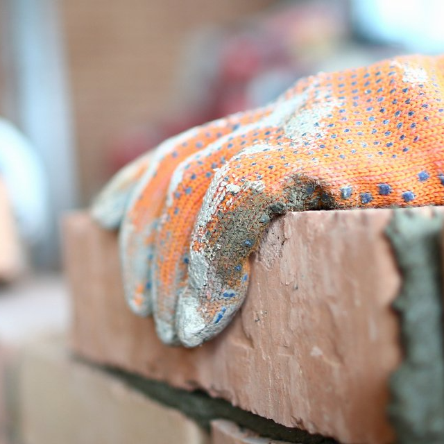 Une main posée sur un moellon