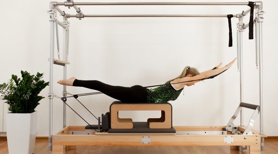 Una mujer está haciendo ejercicios en una máquina de pilates.