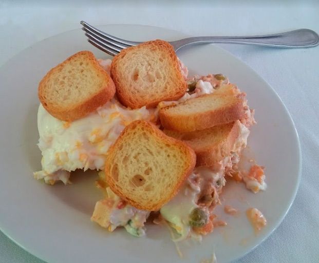 Un plato de comida con pan tostado y un tenedor sobre una mesa.