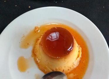 Un primer plano de un postre en un plato con una cuchara.