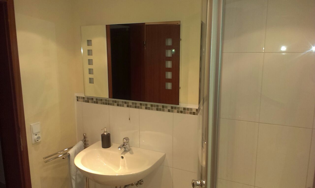Ein Badezimmer mit Waschbecken, Spiegel und Dusche.