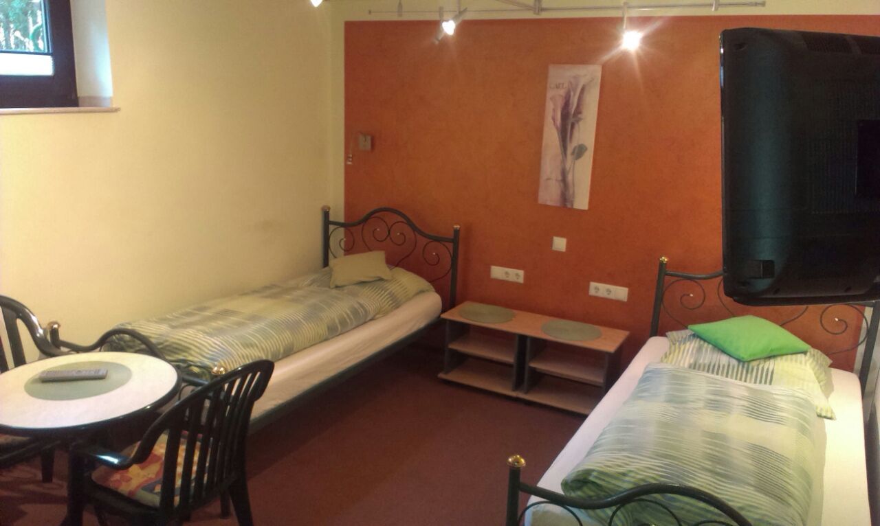 Ein Schlafzimmer mit zwei Betten, einem Tisch und einem Fernseher
